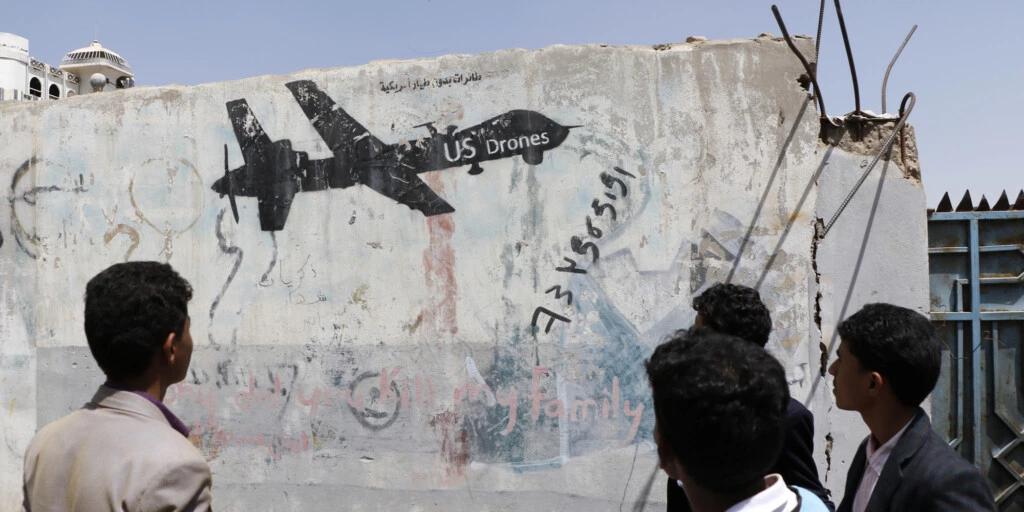 Um homem iemenita observa uma pichação de protesto contra os ataques de drones pelos EUA, em 19 de setembro de 2018 em Sana'a, Iêmen.