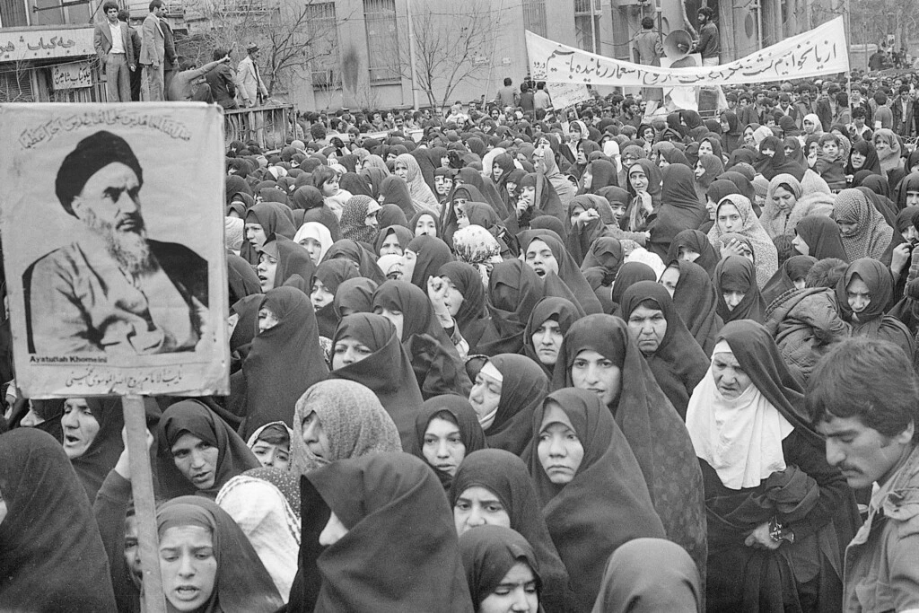 Mulheres muçulmanas reunidas perto de uma placa com a imagem do aiatolá Komeini, durante uma manifestação no início de fevereiro de 1979, em Teerã, no Irã.