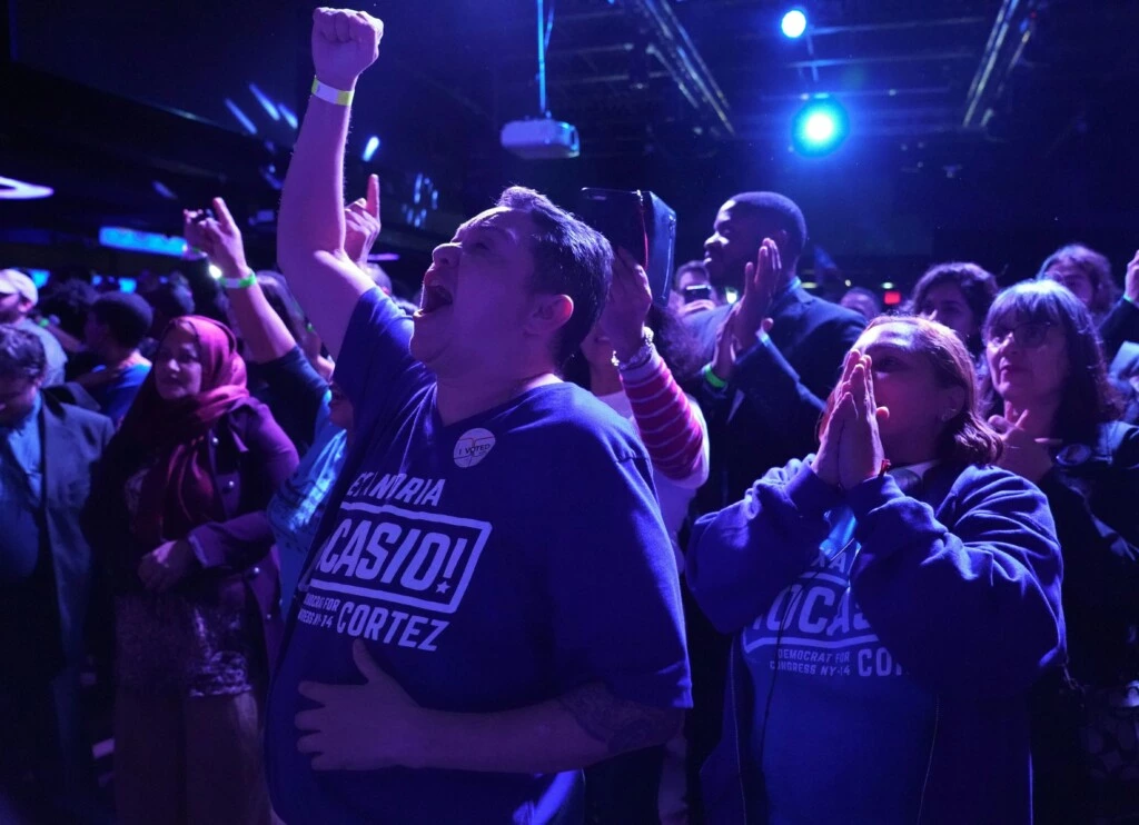 Apoiadores de Alexandria Ocasio-Cortez aplaudem enquanto ela fala no palco durante sua festa eleitoral no Queens, em Nova York, em 6 de novembro.