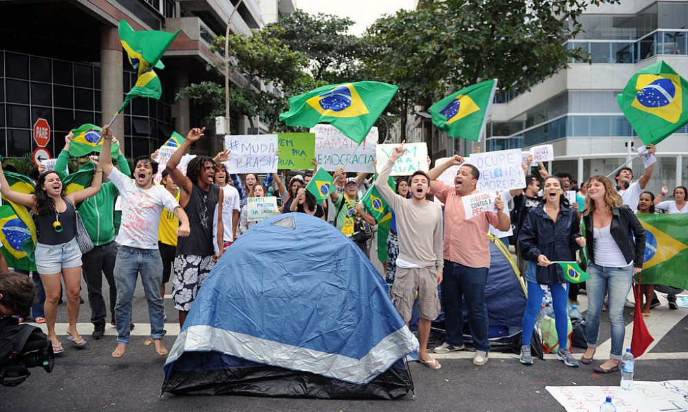 Protesters camping, since last night, in front of the residence of Rio de Janeiro's governor Sergio Cabral, in Leblon, Rio de Janeiro, shout slogans while blocking the street on June 22, 2013. Brazil girded for more street protests Saturday despite President Dilma Rousseff's conciliatory remarks pledging to improve public services and fight corruption, while warning against further violence. Her speech came a day after more than one million people marched in cities across the country to slam the huge cost of hosting next June's World Cup, put at some 15 billion dollars, while public services such as schools and hospitals are lacking. AFP PHOTO / TASSO MARCLEO (Photo credit should read TASSO MARCELO/AFP/Getty Images)