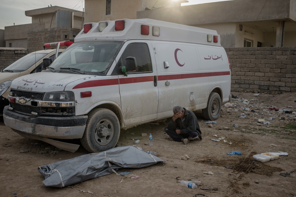 Matham Tarek's father cries near his son's body at a field clinic in the Samah neighborhood of Mosul, Iraq on Nov. 13, 2016. He was killed by a mortar attack.