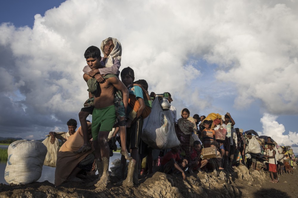 PALONG KHALI, BANGLADESH - OCTOBER 9: Thousands of Rohingya refugees fleeing from Myanmar walk along a muddy rice field after crossing the border in Palang Khali, Cox's Bazar, Bangladesh.  Well over a half a million Rohingya refugees have fled into Bangladesh since late August during the outbreak of violence in Rakhine state causing a humanitarian crisis in the region with continued challenges for aid agencies. (Photo by Paula Bronstein/Getty Images)