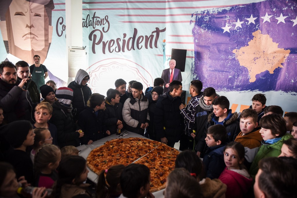 Children gather around a pizza at a restaurant near the town of Ferizaj on January 28, 2017, where 45 pizzas were given for free in honor to the new elected President of the United States of America. / AFP / Armend NIMANI (Photo credit should read ARMEND NIMANI/AFP/Getty Images)