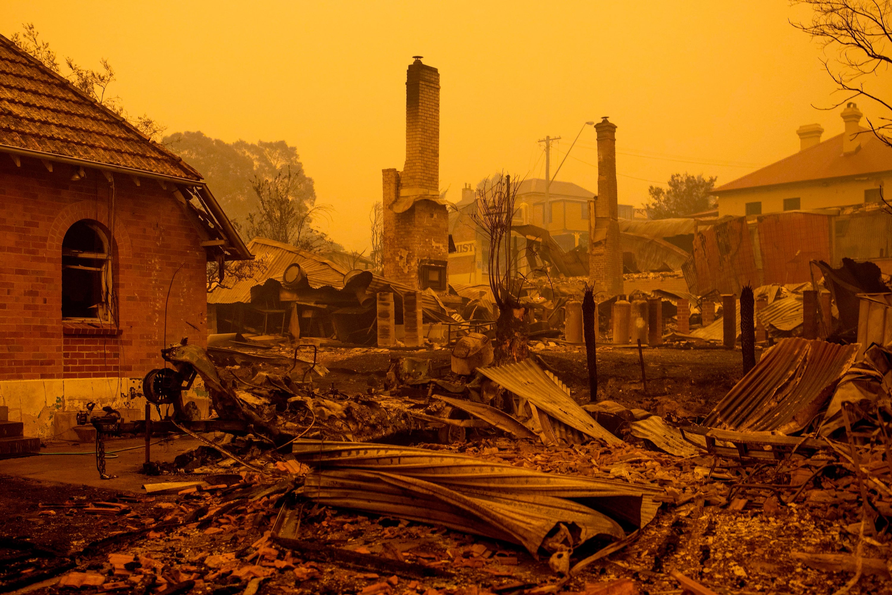 The remains of burnt out buildings are seen along main street in the New South Wales town of Cobargo on December 31, 2019, after bushfires ravaged the town. - Thousands of holidaymakers and locals were forced to flee to beaches in fire-ravaged southeast Australia on December 31, as blazes ripped through popular tourist areas leaving no escape by land. (Photo by SEAN DAVEY/AFP via Getty Images)